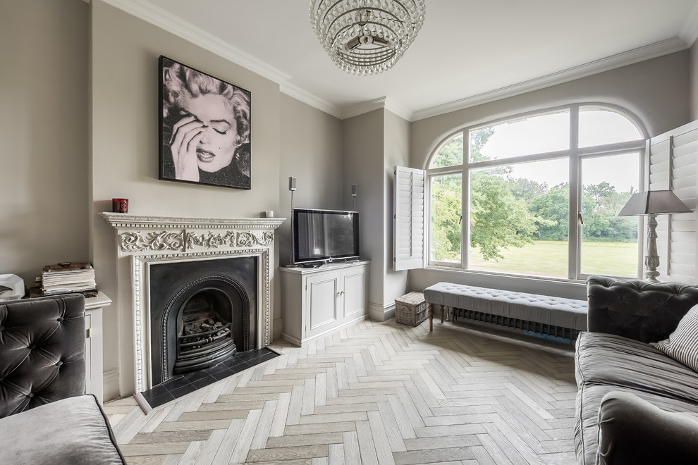 Mittelgroßes Klassisches Wohnzimmer mit grauer Wandfarbe, hellem Holzboden, freistehendem TV und grauem Boden in London