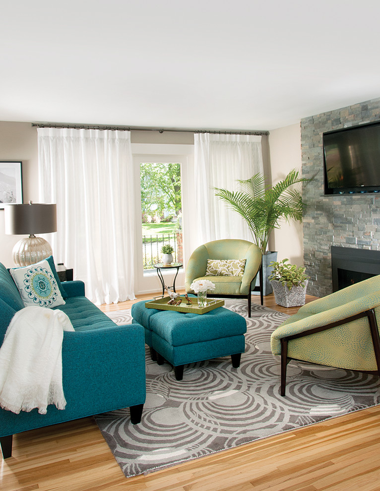 Inspiration for a small contemporary grey and teal open plan living room in New York with beige walls, light hardwood flooring, a two-sided fireplace, a stone fireplace surround, a wall mounted tv and feature lighting.