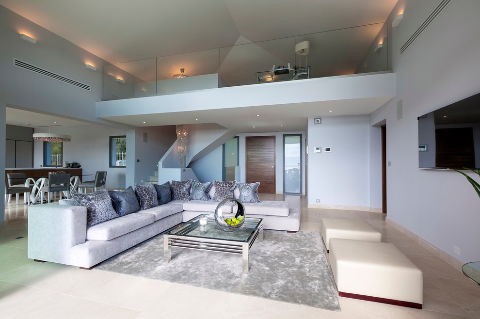 На фото: открытая гостиная комната в современном стиле с телевизором на стене и ковром на полу с