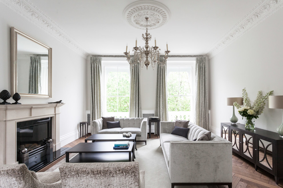 Abgetrenntes Klassisches Wohnzimmer mit weißer Wandfarbe, braunem Holzboden, Kamin und braunem Boden in London