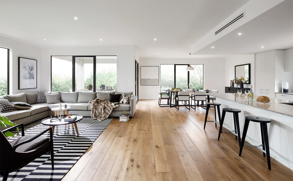 Idee per un grande soggiorno contemporaneo con pareti bianche, pavimento in legno massello medio e pavimento marrone
