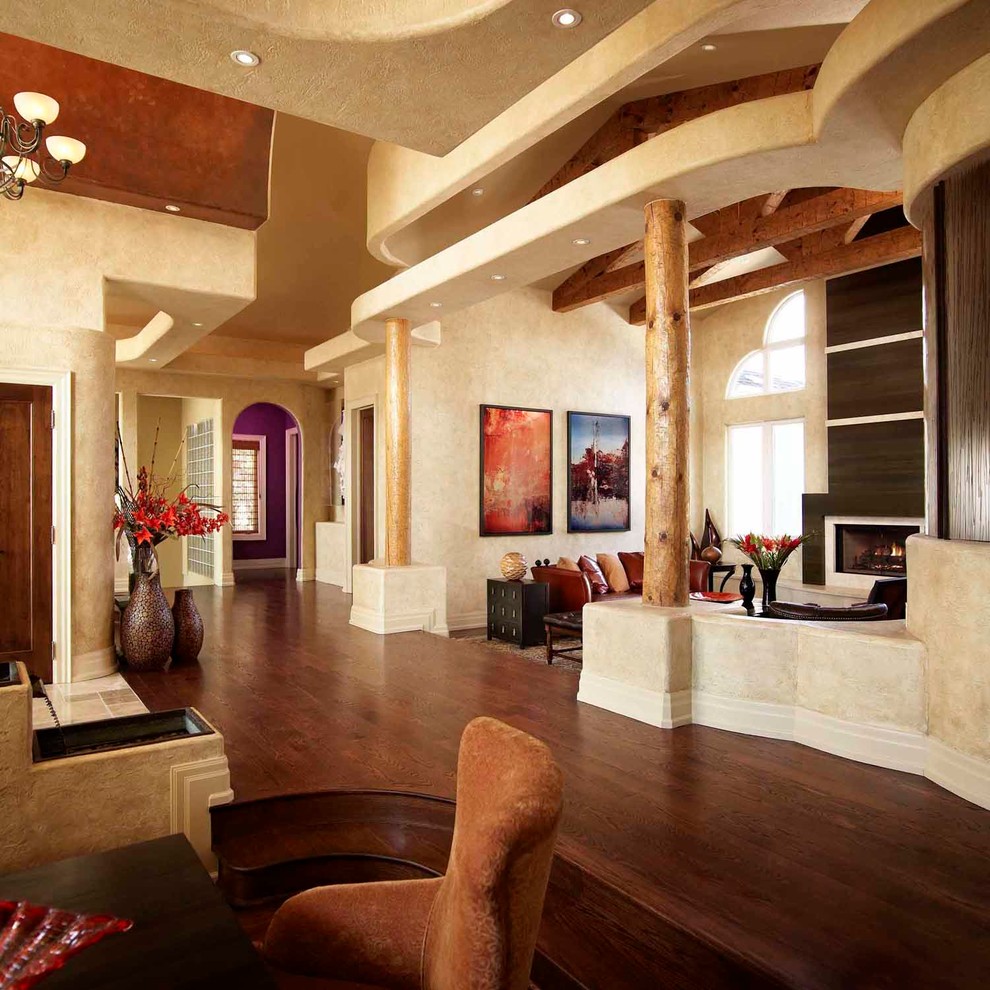 Idée de décoration pour un salon sud-ouest américain de taille moyenne et ouvert avec une cheminée standard, aucun téléviseur, une salle de réception, un mur beige, un sol en bois brun et un manteau de cheminée en bois.