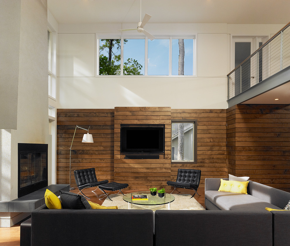 Modelo de salón abierto minimalista extra grande con paredes blancas, suelo de madera en tonos medios, todas las chimeneas, marco de chimenea de yeso y pared multimedia