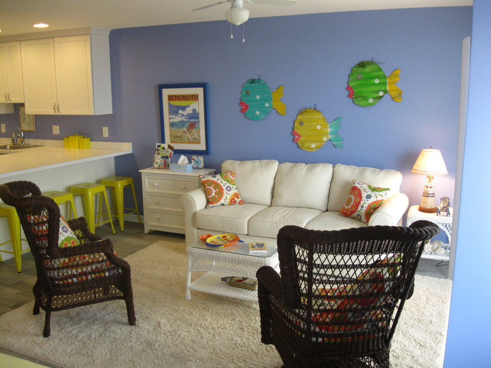 Idee per un piccolo soggiorno costiero aperto con pareti blu, parquet scuro e TV a parete
