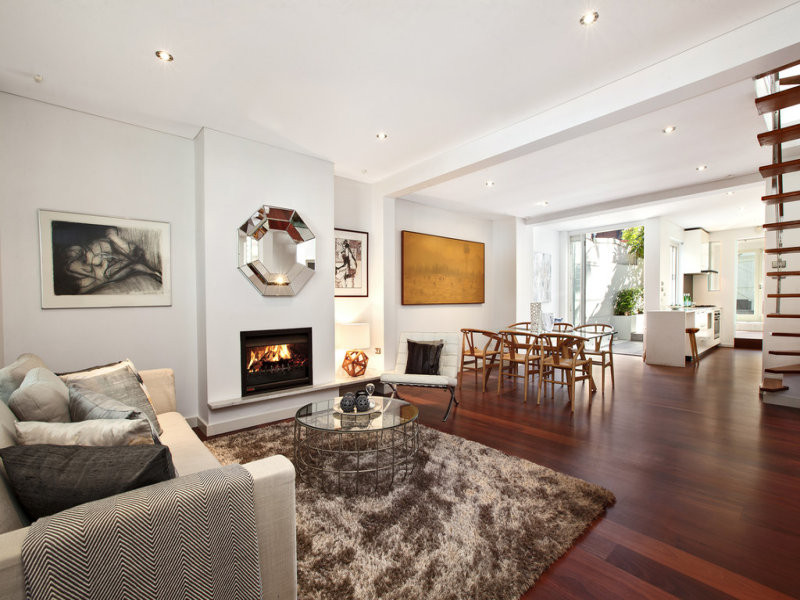 シドニーにある高級な小さなモダンスタイルのおしゃれなLDK (白い壁、無垢フローリング、標準型暖炉、金属の暖炉まわり、茶色い床、折り上げ天井) の写真