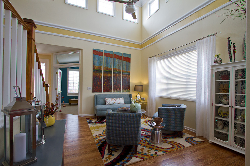 На фото: большая открытая гостиная комната в морском стиле с желтыми стенами, паркетным полом среднего тона и коричневым полом без камина, телевизора с