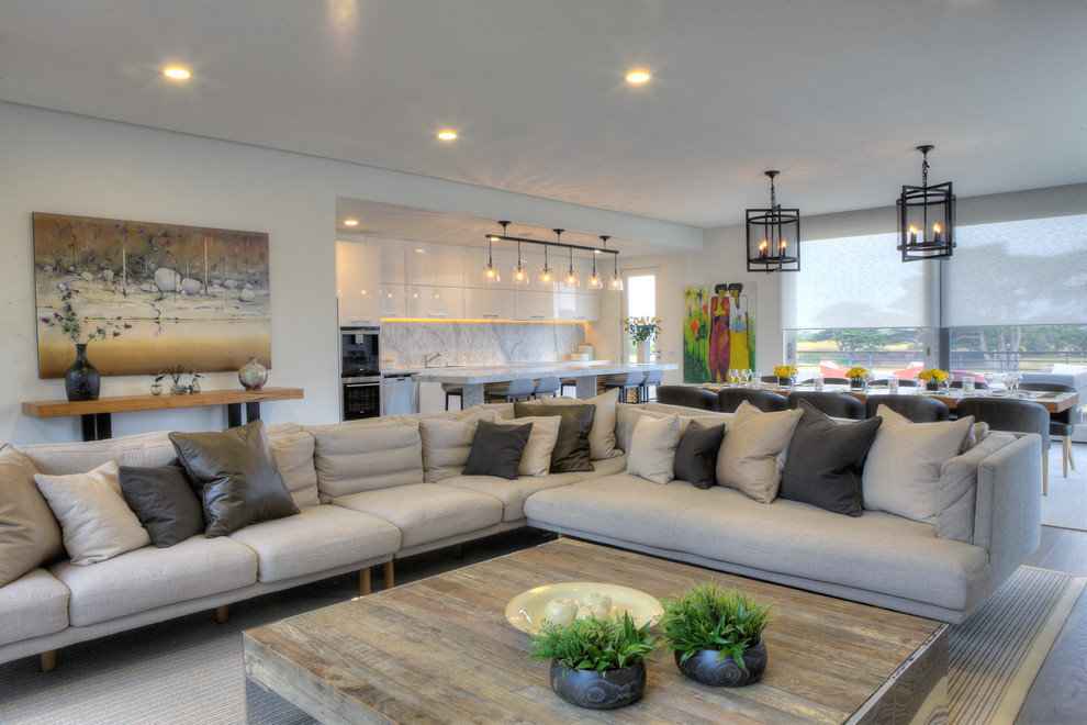 Immagine di un ampio soggiorno contemporaneo aperto con pareti bianche, parquet chiaro e TV a parete