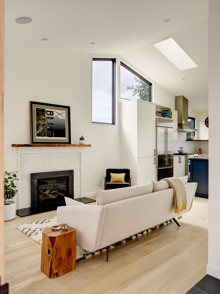 Свежая идея для дизайна: гостиная комната в стиле неоклассика (современная классика) с белыми стенами, светлым паркетным полом, стандартным камином и фасадом камина из камня - отличное фото интерьера