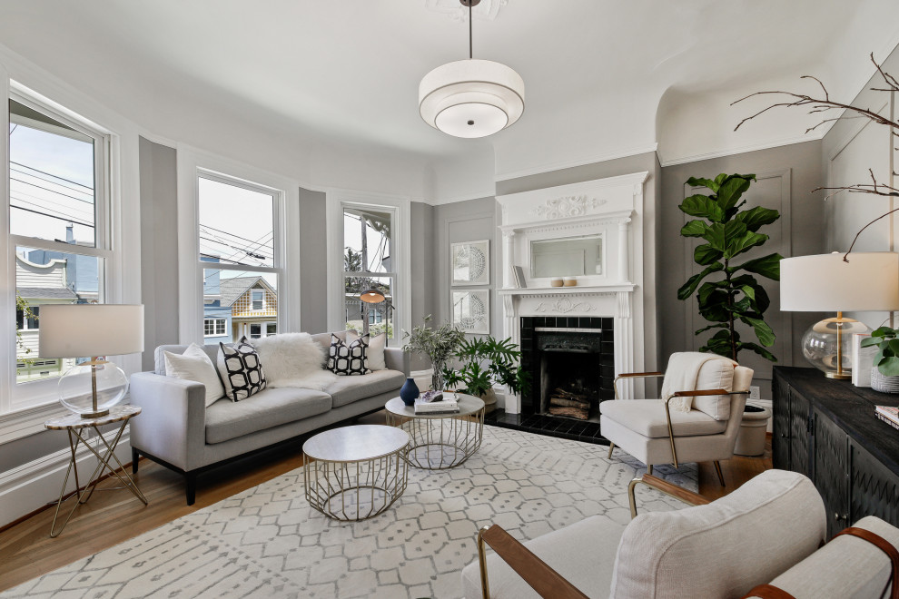 Immagine di un soggiorno classico con pareti grigie, parquet scuro, camino classico, pavimento marrone e pannellatura