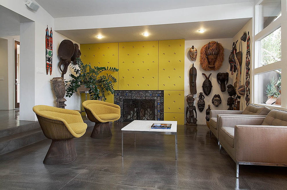 Foto di un soggiorno design con pareti gialle, camino classico e cornice del camino piastrellata