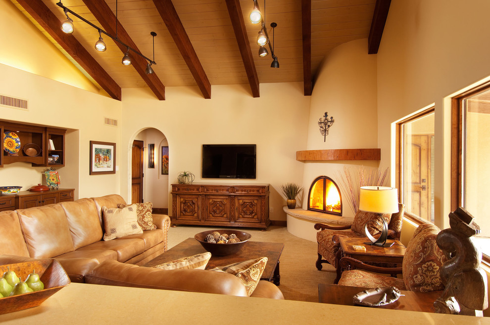 Cette photo montre un grand salon chic ouvert avec une cheminée d'angle, un téléviseur fixé au mur, un mur beige, moquette et un manteau de cheminée en plâtre.