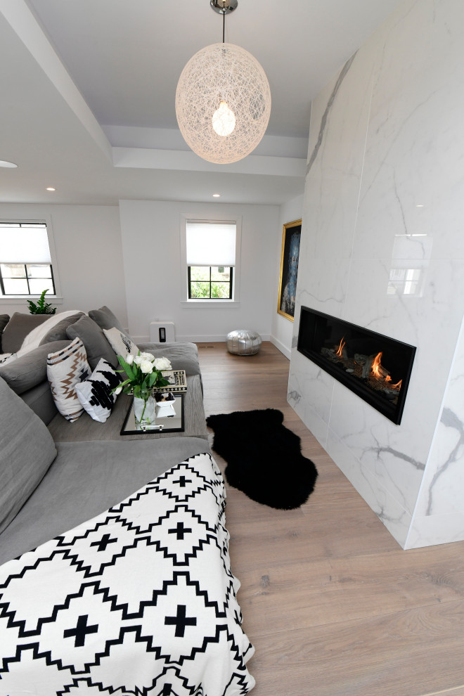 Idée de décoration pour un grand salon minimaliste ouvert avec un mur blanc, parquet clair, une cheminée standard, un manteau de cheminée en pierre et un plafond à caissons.