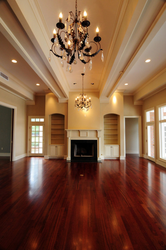 Example of a large classic formal and enclosed dark wood floor living room design in New Orleans with beige walls, a wood stove and a wood fireplace surround