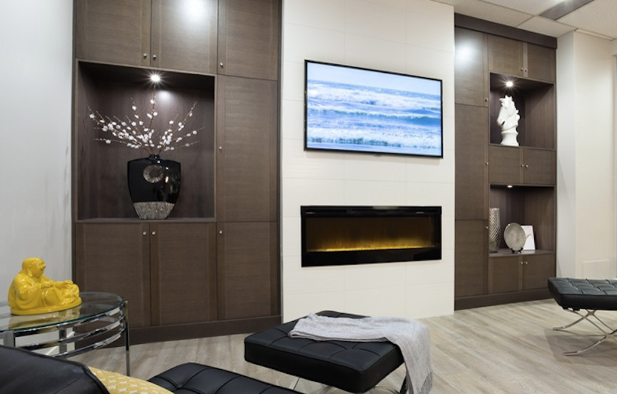 Modelo de salón abierto actual con paredes blancas, marco de chimenea de piedra y televisor colgado en la pared