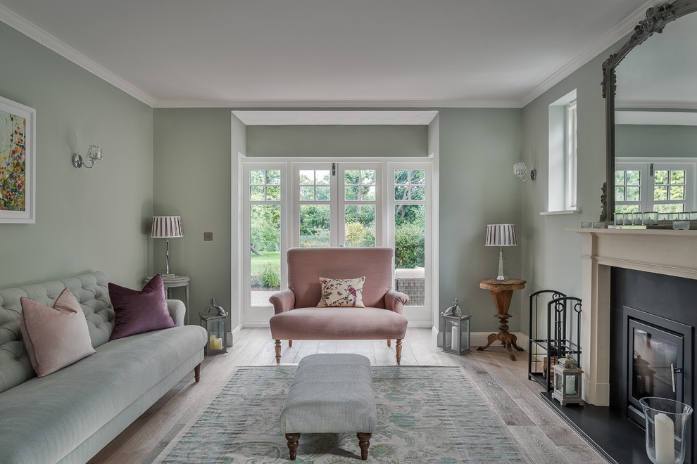 Mittelgroßes, Repräsentatives, Fernseherloses, Abgetrenntes Klassisches Wohnzimmer mit grüner Wandfarbe, hellem Holzboden, Kamin und Kaminumrandung aus Stein in Surrey