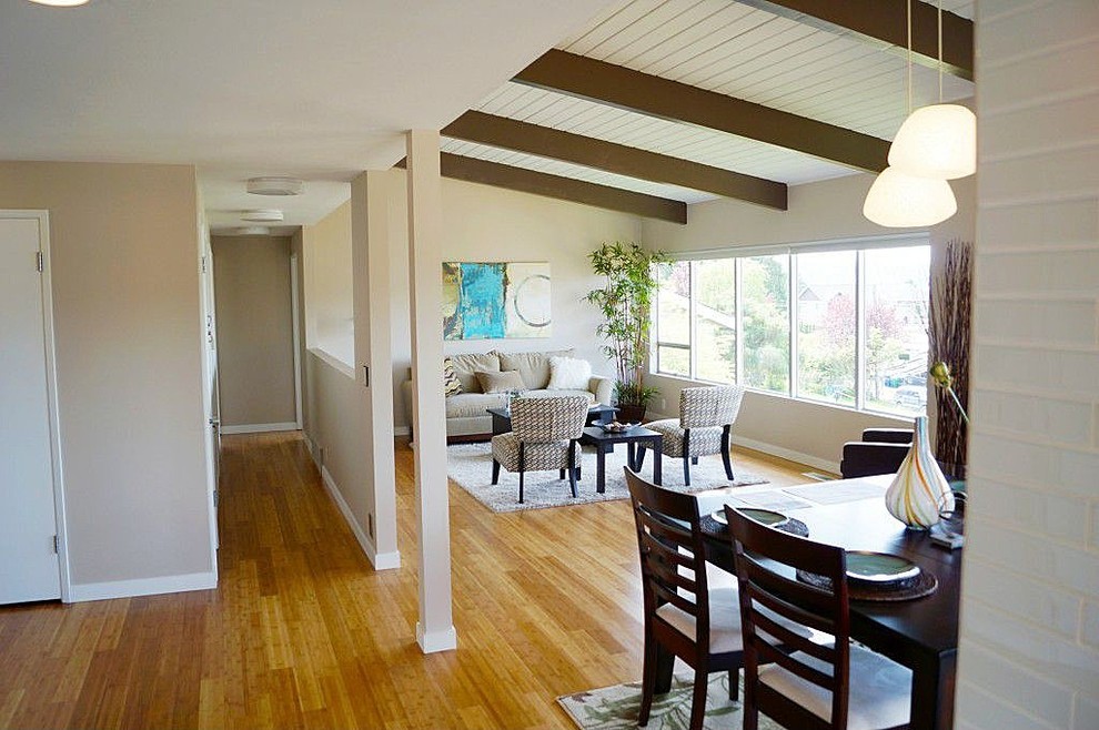 Esempio di un soggiorno classico aperto e di medie dimensioni con pareti beige, pavimento in bambù, sala formale, nessuna TV e pavimento marrone