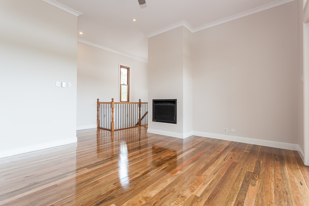 Example of an open concept medium tone wood floor living room design in Brisbane with beige walls, a standard fireplace, a plaster fireplace and a media wall