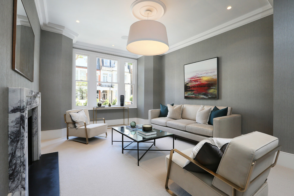 Свежая идея для дизайна: гостиная комната среднего размера в стиле неоклассика (современная классика) с серыми стенами, ковровым покрытием, стандартным камином, фасадом камина из камня и бежевым полом - отличное фото интерьера