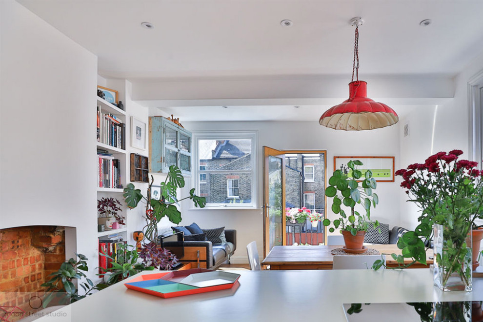 Mittelgroßes, Offenes Modernes Wohnzimmer ohne Kamin mit weißer Wandfarbe, braunem Holzboden, verputzter Kaminumrandung, freistehendem TV und braunem Boden in London