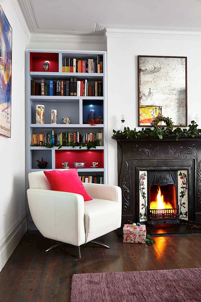 Esempio di un soggiorno classico con libreria, pareti bianche, parquet scuro e camino classico