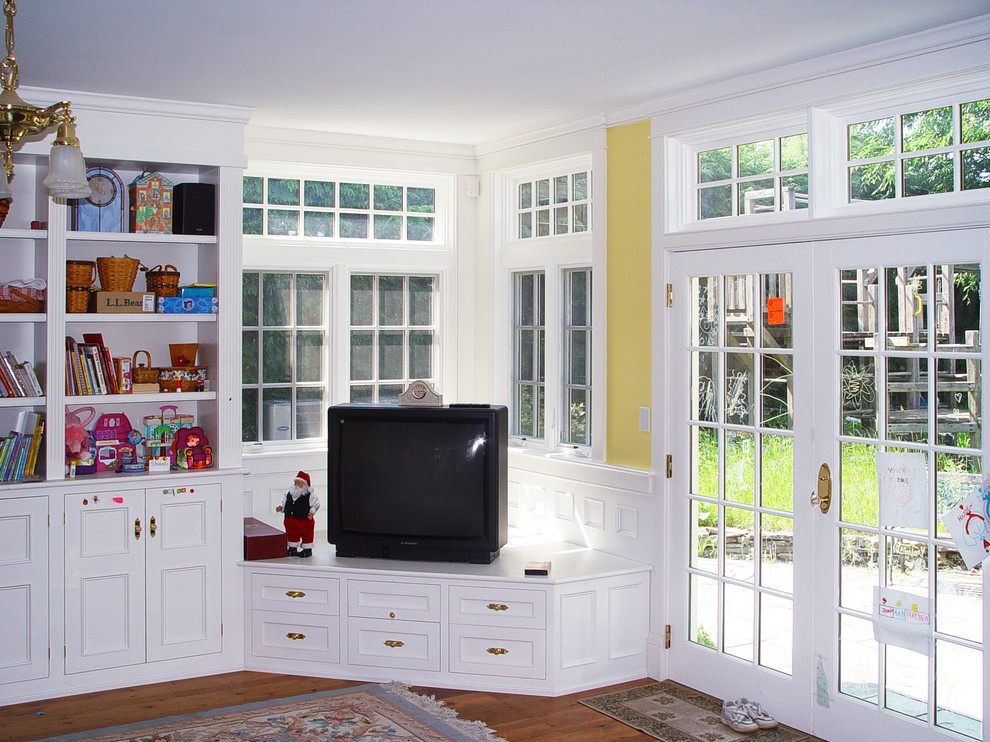 На фото: открытая гостиная комната в классическом стиле с желтыми стенами, паркетным полом среднего тона и телевизором в углу без камина с