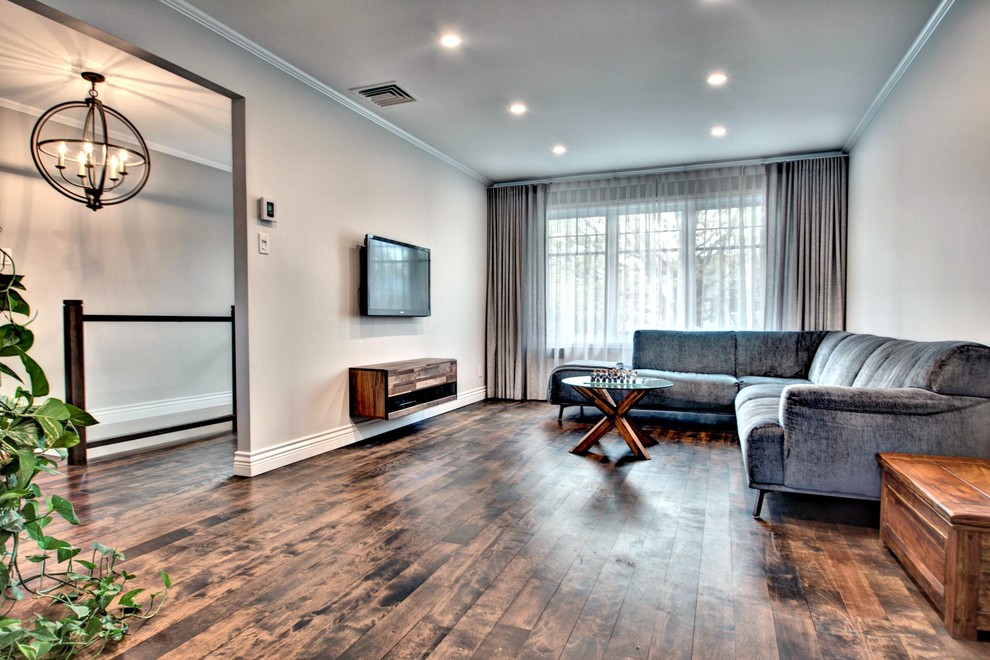 This is an example of a medium sized contemporary open plan living room in Montreal with a wall mounted tv.