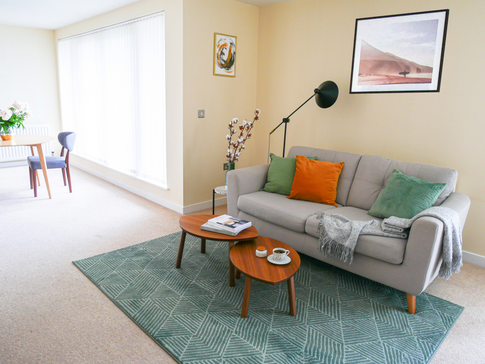 Medium sized scandi open plan living room in Edinburgh with yellow walls, carpet, no fireplace, a freestanding tv and beige floors.