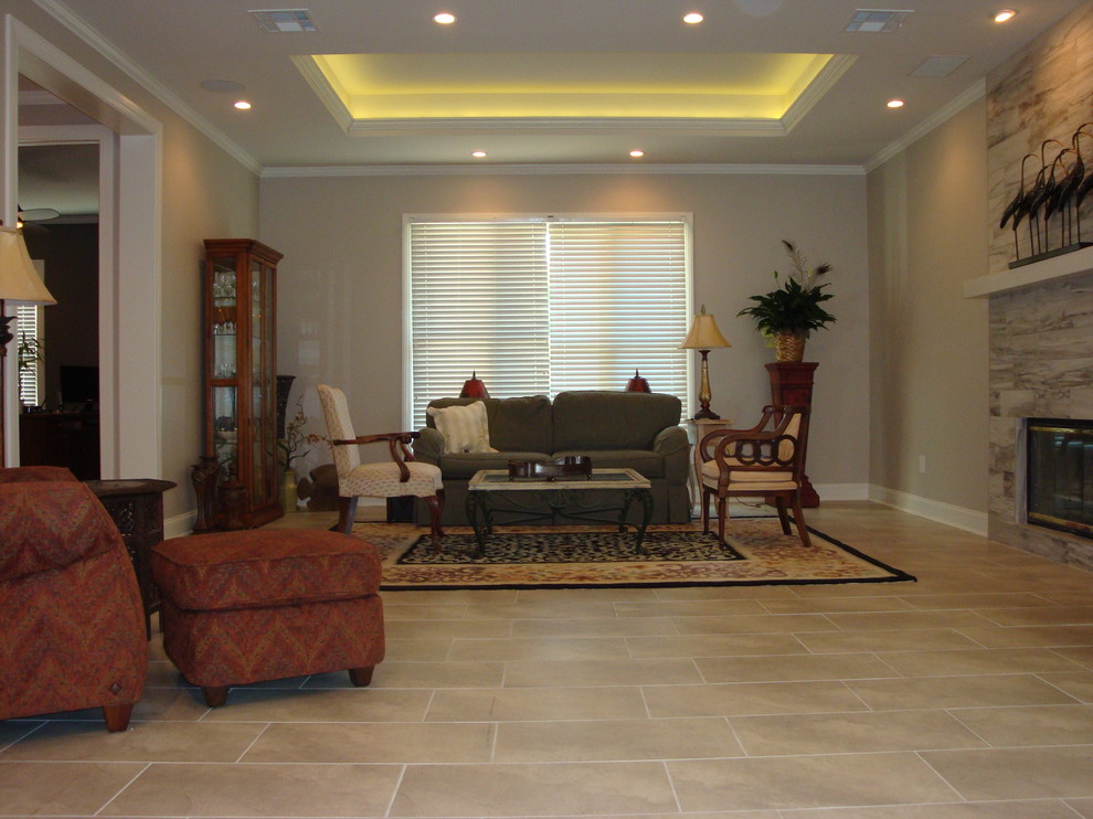 ジャクソンにあるラグジュアリーな広いトランジショナルスタイルのおしゃれなリビング (グレーの壁、セラミックタイルの床、標準型暖炉、タイルの暖炉まわり、壁掛け型テレビ) の写真