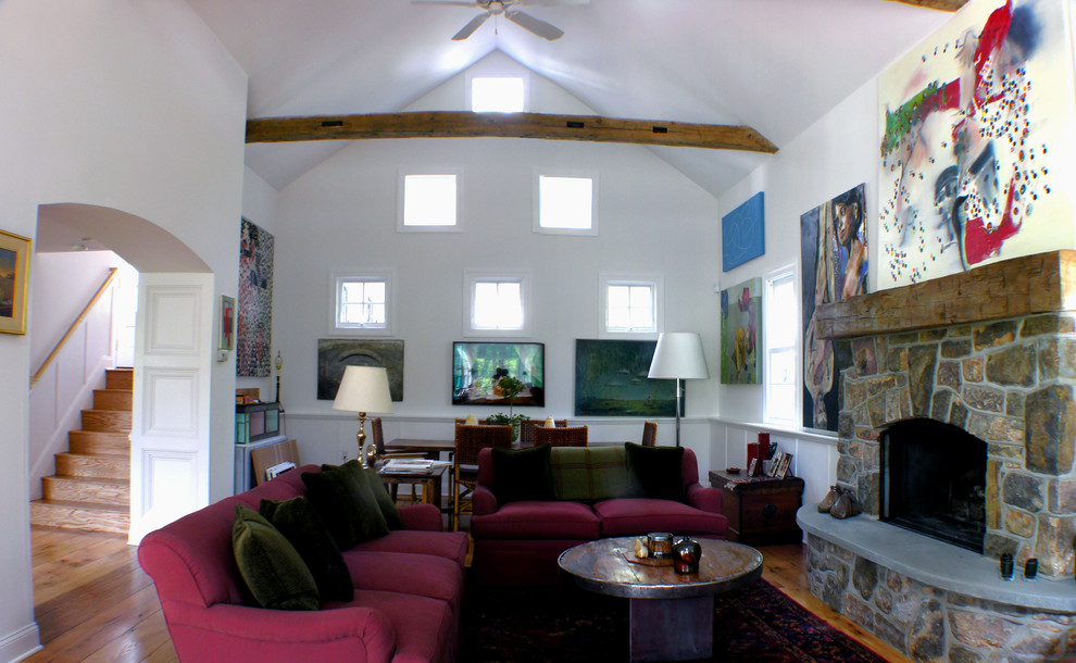 Imagen de salón abierto clásico grande con paredes blancas, suelo de madera en tonos medios, todas las chimeneas y marco de chimenea de piedra