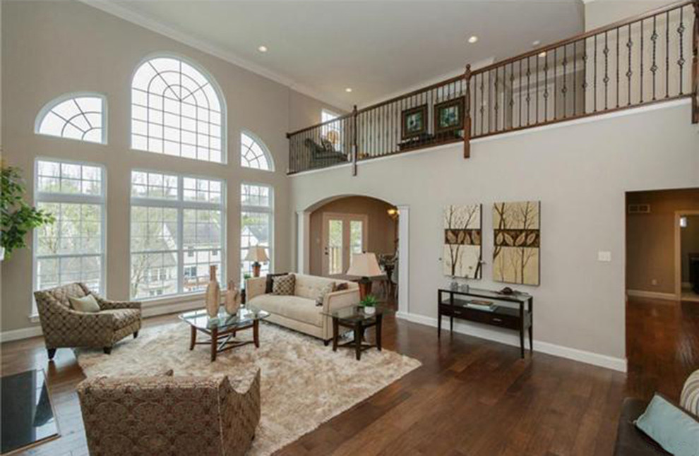 This is an example of a large classic formal open plan living room in St Louis with beige walls, dark hardwood flooring, no fireplace and no tv.
