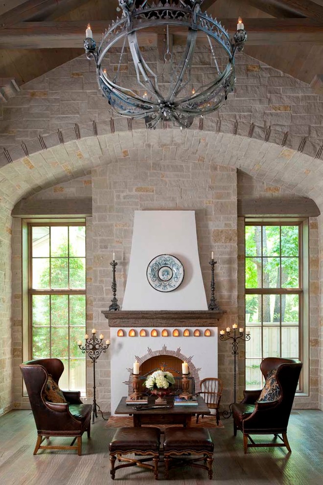 Example of a tuscan formal medium tone wood floor living room design in Dallas with a standard fireplace