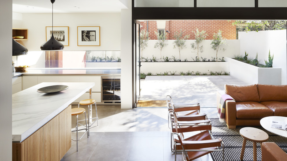 Mittelgroßes, Fernseherloses, Offenes Modernes Wohnzimmer mit weißer Wandfarbe und Betonboden in Melbourne