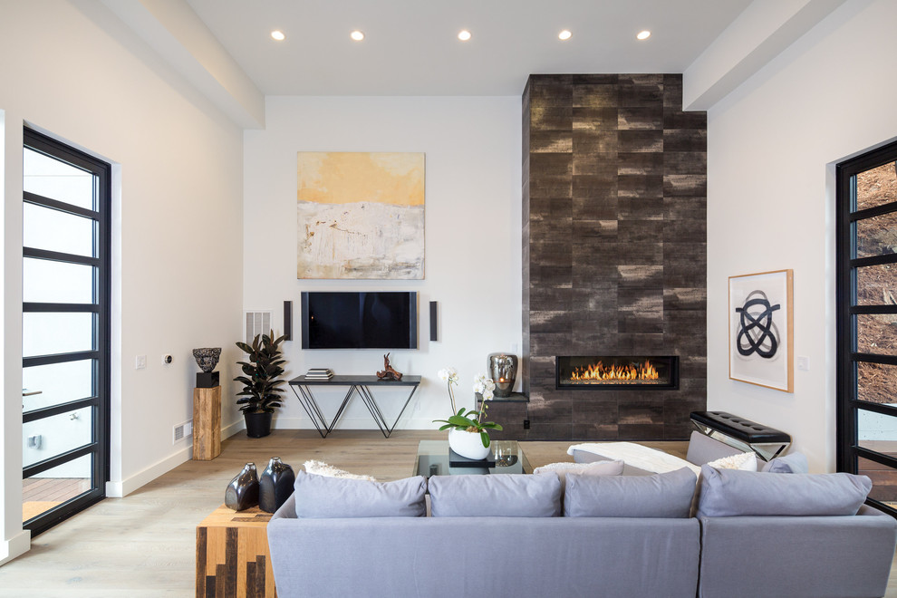 Exempel på ett modernt allrum med öppen planlösning, med ett finrum, vita väggar, ljust trägolv, en bred öppen spis, en väggmonterad TV och beiget golv