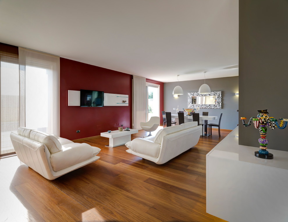 Идея дизайна: гостиная комната в современном стиле с красными стенами и паркетным полом среднего тона