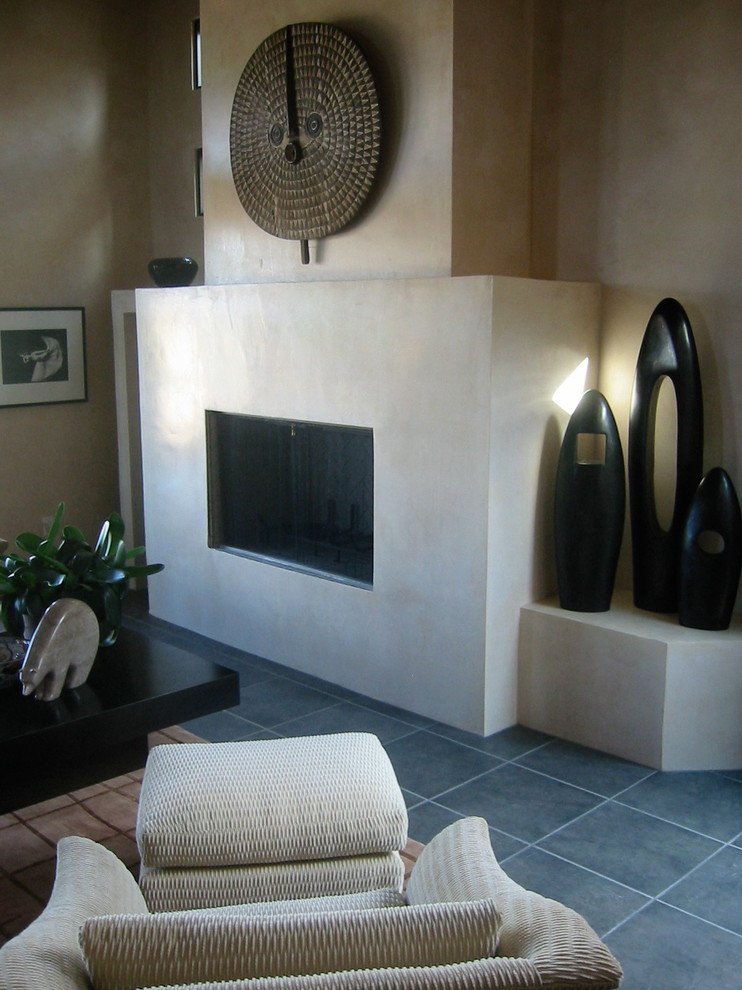 Exemple d'un salon tendance de taille moyenne et fermé avec un mur beige, un sol en carrelage de céramique, une cheminée standard et un manteau de cheminée en pierre.