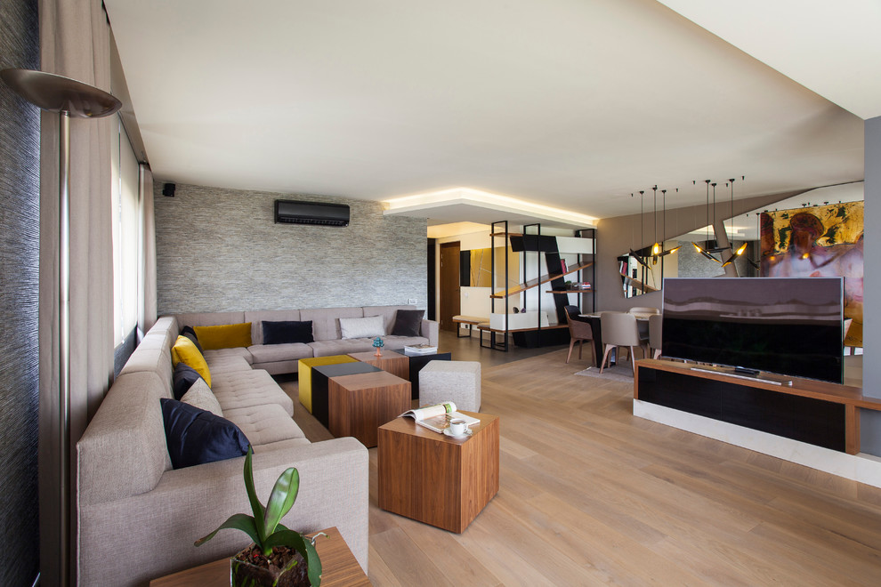 Idee per un soggiorno design aperto con pareti marroni, parquet chiaro e TV autoportante