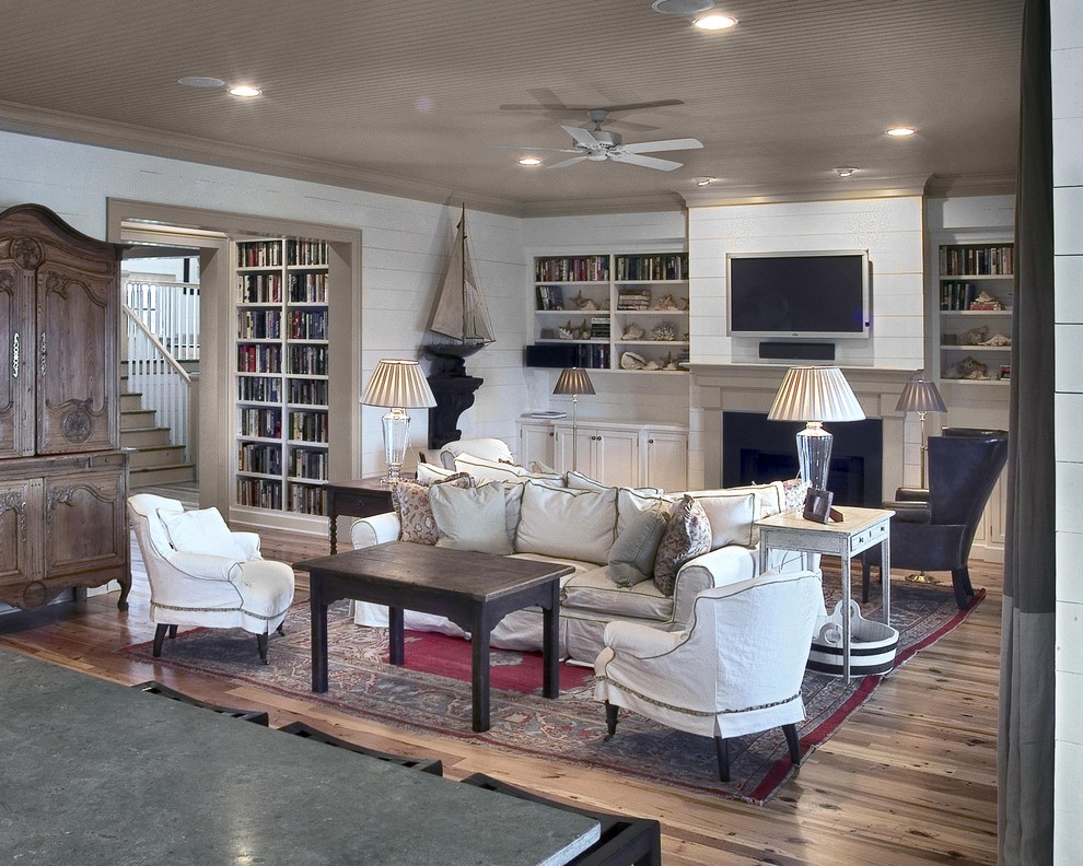 Beach style living room photo in Charleston with white walls, a standard fireplace and a wall-mounted tv