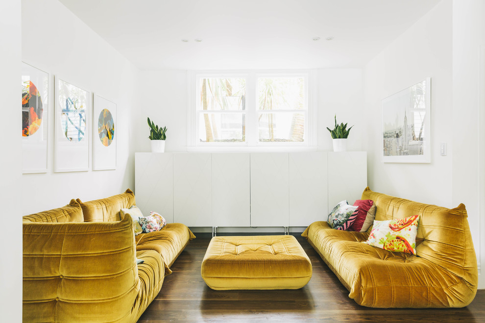Стильный дизайн: изолированная гостиная комната в стиле фьюжн с белыми стенами, темным паркетным полом и коричневым полом без телевизора - последний тренд