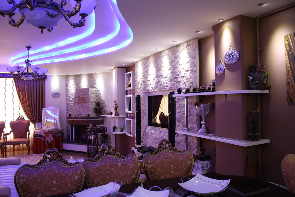 Modelo de salón minimalista de tamaño medio con paredes multicolor, chimenea de doble cara, marco de chimenea de ladrillo y pared multimedia