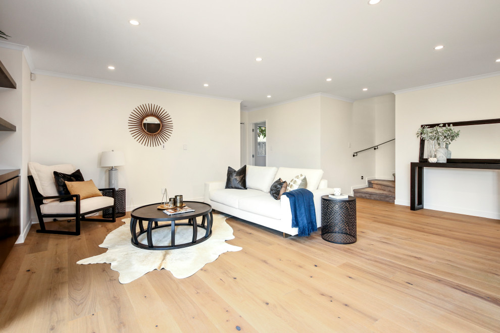 Inspiration for a mid-sized modern formal and open concept light wood floor and beige floor living room remodel in Auckland with white walls and no tv