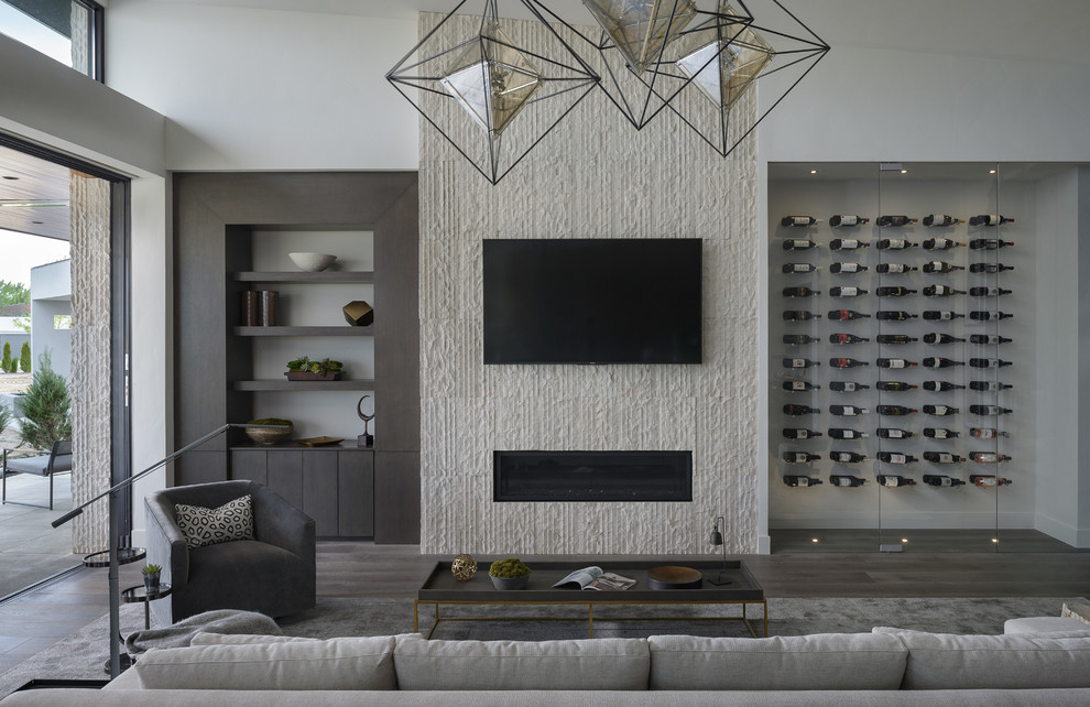 Ejemplo de salón actual con paredes blancas, suelo de madera en tonos medios, chimenea lineal, televisor colgado en la pared y suelo gris