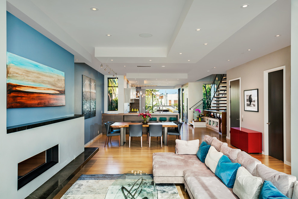 Cette photo montre un salon tendance ouvert avec une salle de réception, un mur bleu, une cheminée ribbon et aucun téléviseur.