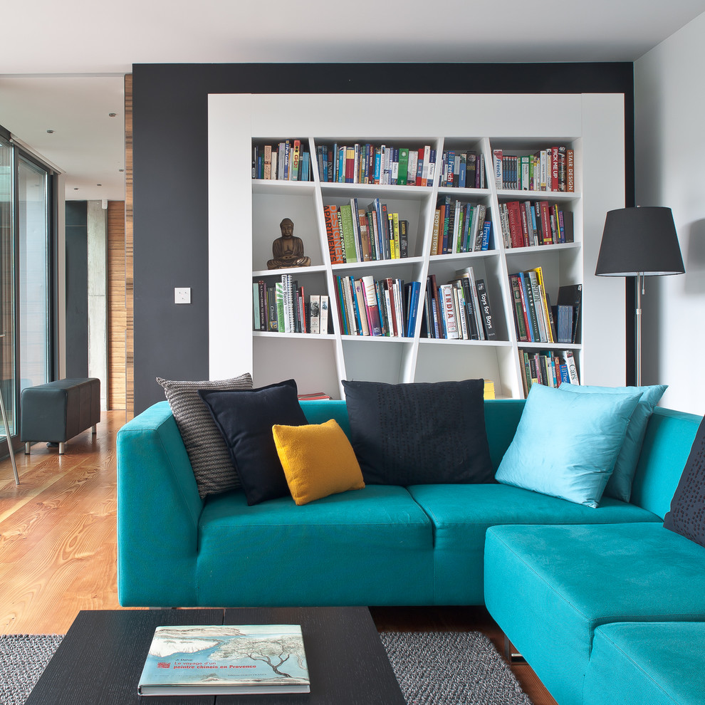 На фото: гостиная комната в современном стиле с синим диваном