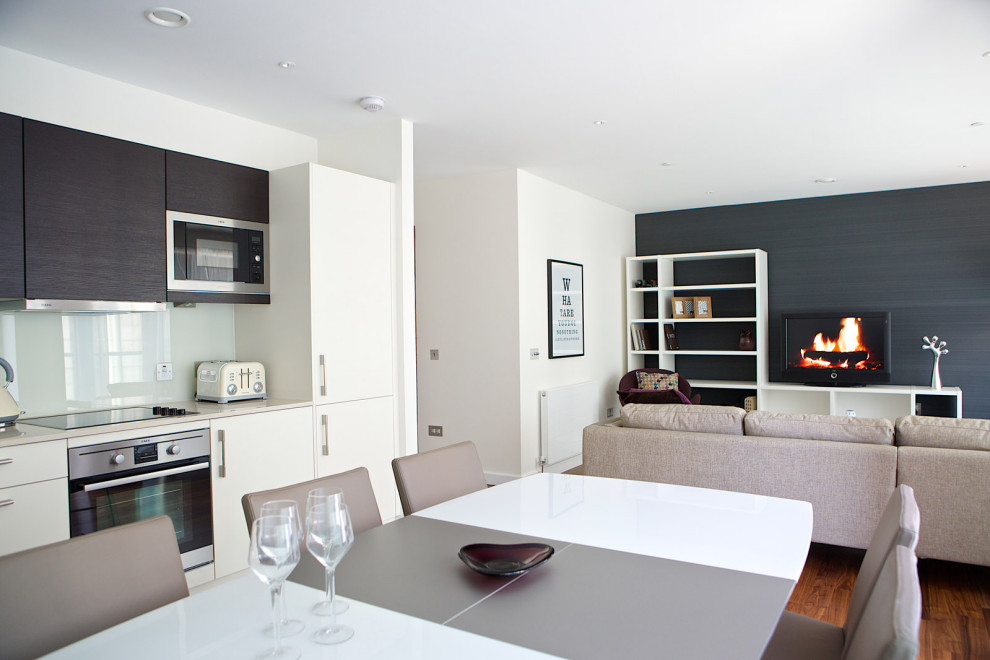 На фото: открытая гостиная комната среднего размера в современном стиле с синими стенами, светлым паркетным полом, отдельно стоящим телевизором и серым полом с