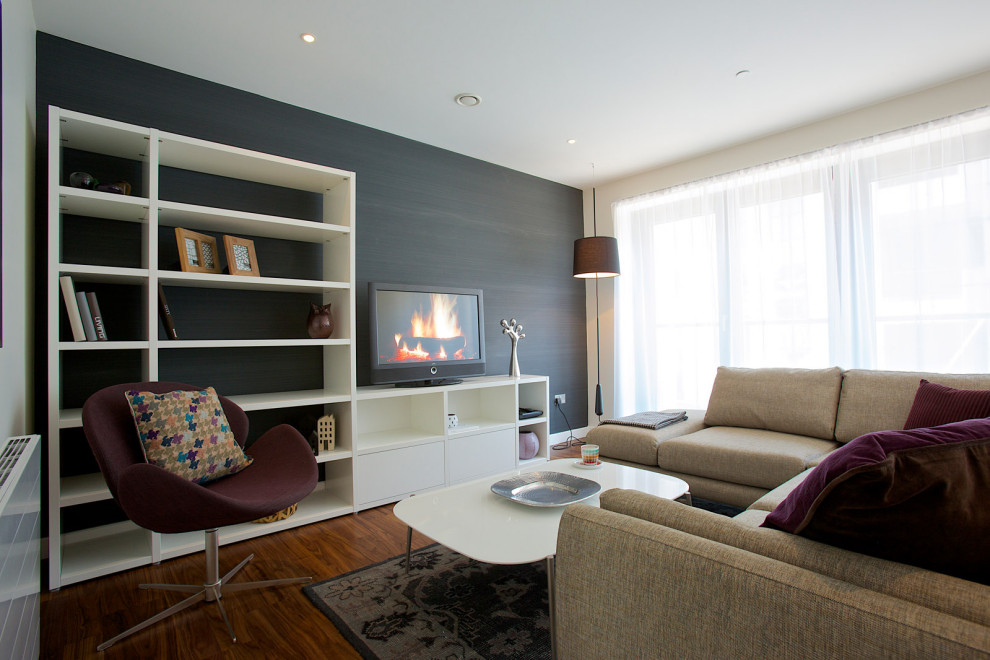 Esempio di un soggiorno design di medie dimensioni e aperto con pareti blu, parquet chiaro, TV autoportante e pavimento grigio