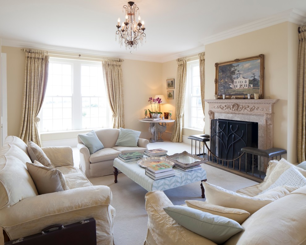 Offenes Klassisches Wohnzimmer mit beiger Wandfarbe, Kamin und Kaminumrandung aus Stein in Gloucestershire