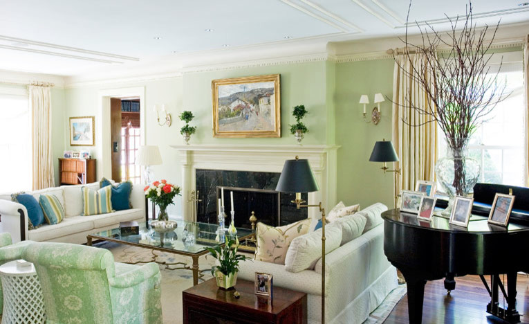 Idée de décoration pour un salon tradition avec une salle de réception, un mur vert, un sol en bois brun, une cheminée standard et un manteau de cheminée en plâtre.