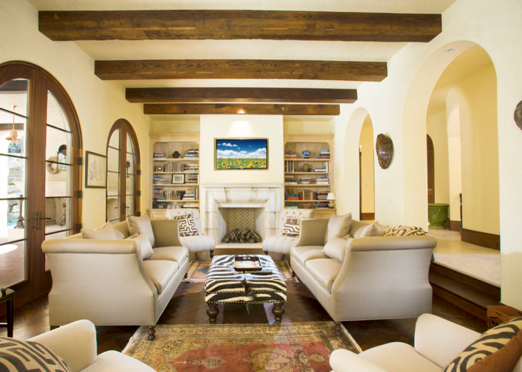 Inspiration for a large mediterranean enclosed living room in Atlanta with yellow walls, dark hardwood flooring, a standard fireplace, a stone fireplace surround, a wall mounted tv and brown floors.