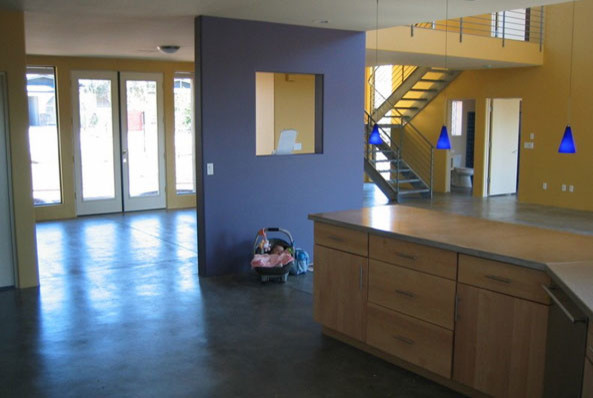 На фото: двухуровневая гостиная комната в стиле модернизм с желтыми стенами и бетонным полом с