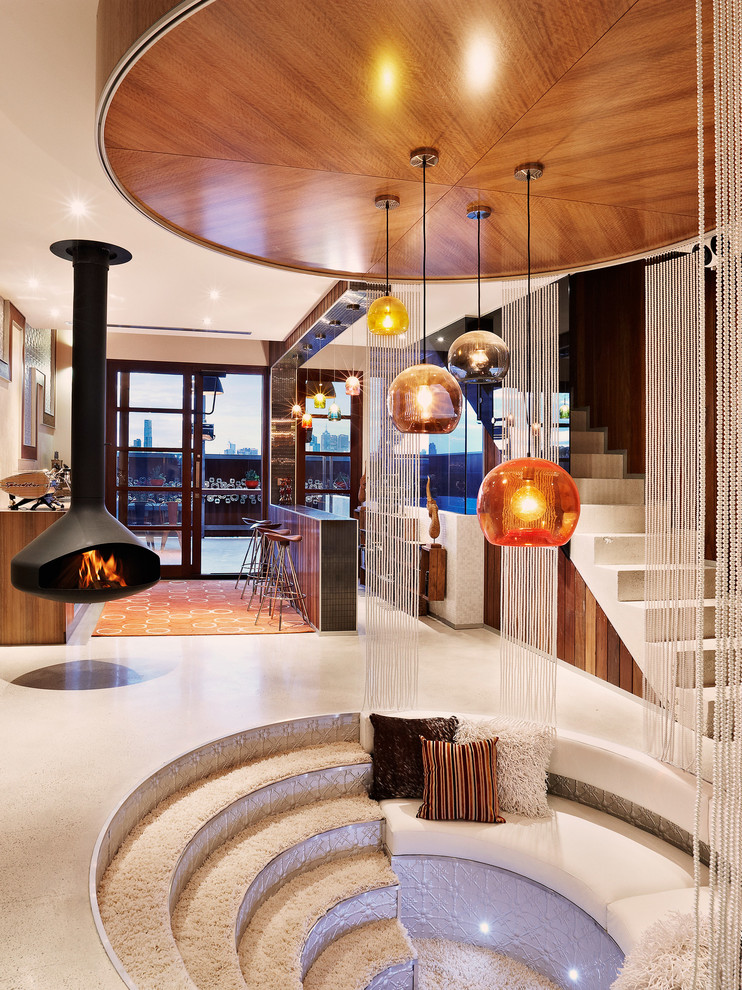 Идея дизайна: большая открытая гостиная комната в современном стиле с коричневыми стенами, бетонным полом, подвесным камином, телевизором на стене и белым полом